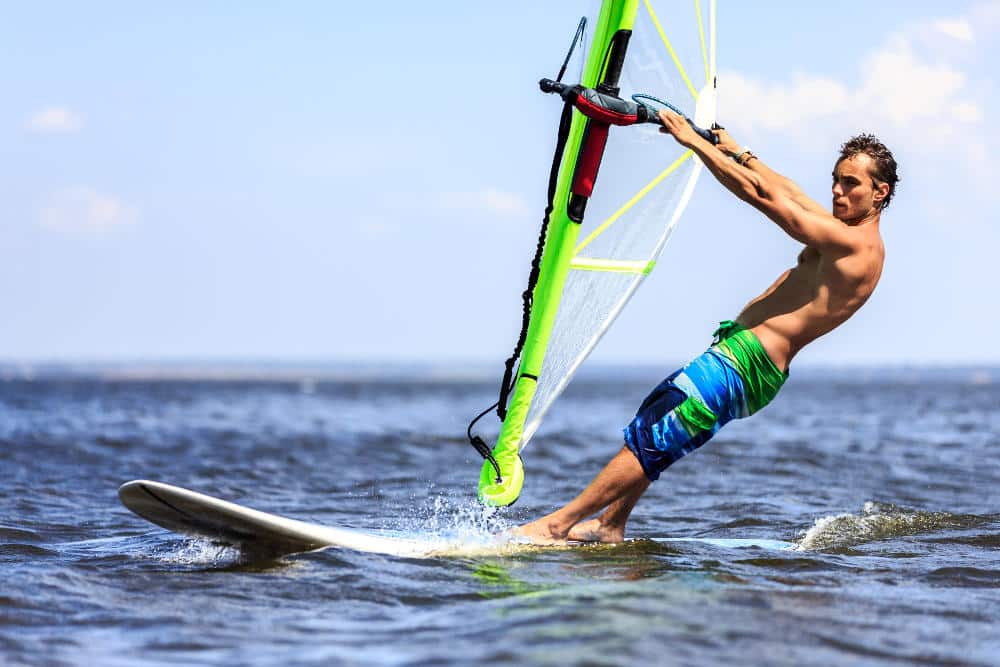Young man surfing the wind on a bright summer day